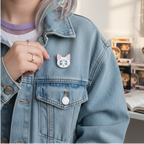 Fans Geek Store Sailor Moon Artemis metal pin attached to a blue denim jacket worn by a person