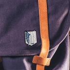Fans Geek Store Attack on Titan Scouts metal pin featuring the Wings of Freedom emblem attached to a purple bag