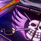 Fans Geek Store One Piece Baroque Works themed envelope with purple skull and wing logo on a wooden surface