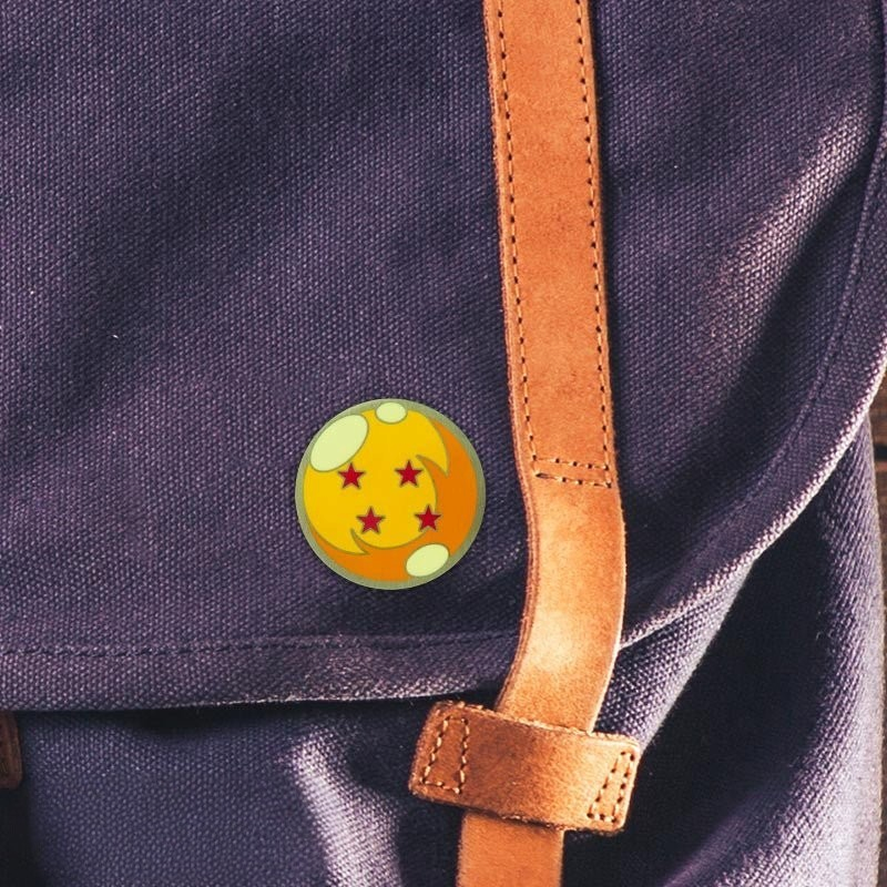 Fans Geek Store metal Dragon Ball four-star pin attached to a dark purple fabric backpack strap