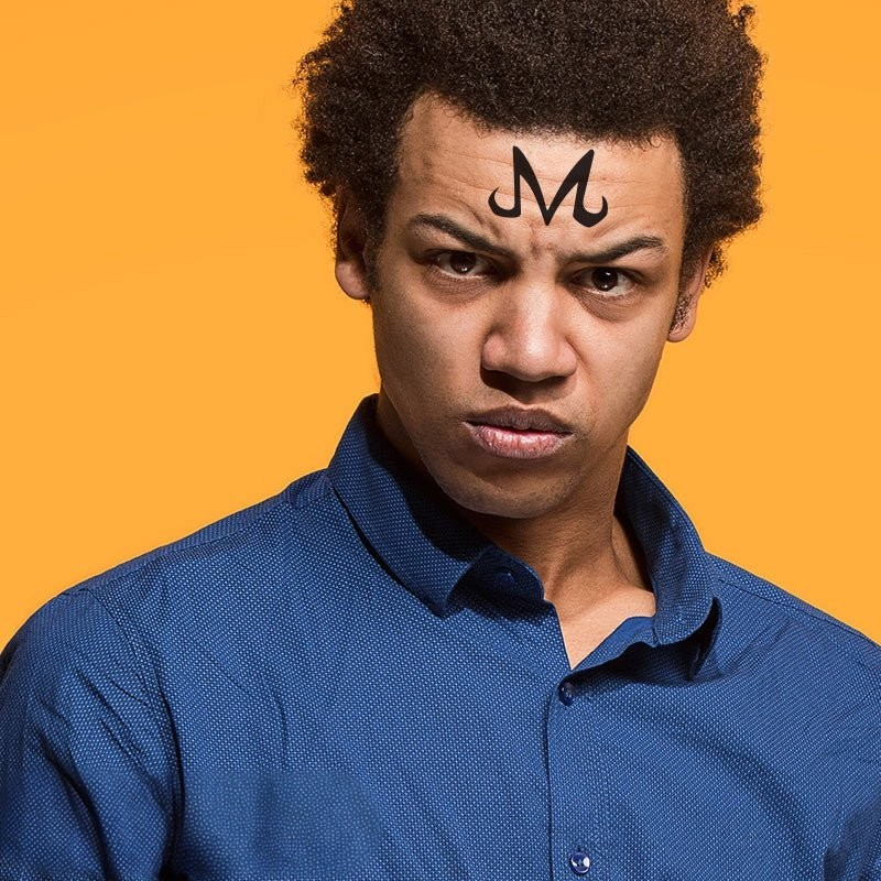 Fans Geek Store temporary Dragon Ball Majin M tattoo on a young man's forehead against a bright yellow background
