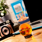Fans Geek Store 4-star Dragon Ball replica in orange acrylic with display stand on a wooden desk