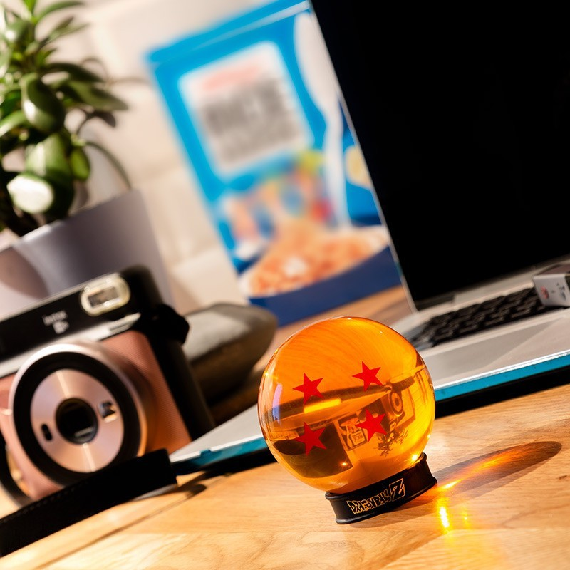 Fans Geek Store 4-star Dragon Ball replica in orange acrylic with display stand on a wooden desk