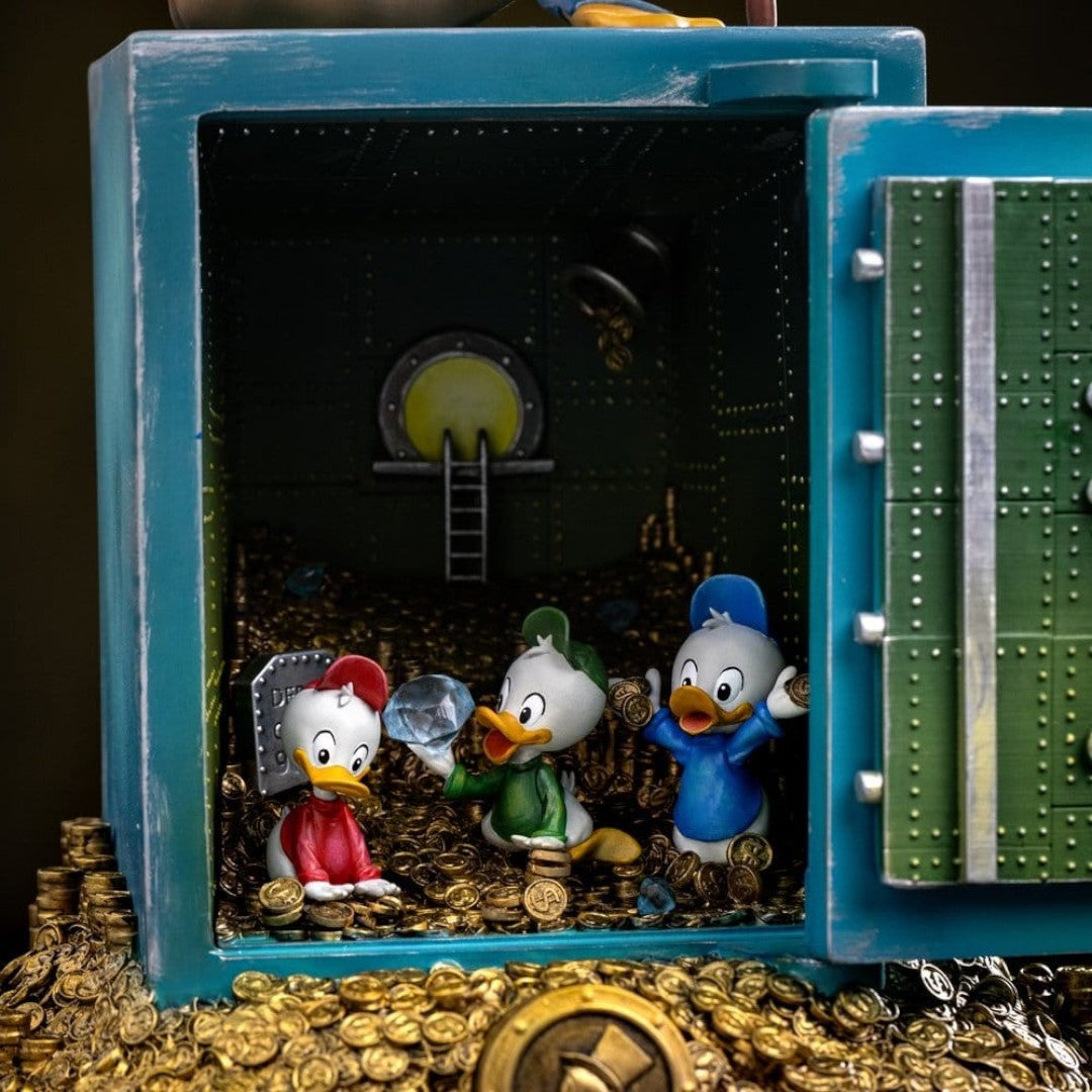 Iron Studios Duck Tales Art Scale Statue 1/10 Uncle Scrooge McDuck & Nephews 30 cm, hand-painted polystone statue of Uncle Scrooge McDuck and nephews Huey, Dewey, and Louie inside a vault filled with gold coins and diamonds.