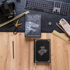 Fans Geek Store Game of Thrones House Stark notebooks with embossed wolf sigils and gold foil on a wooden desk