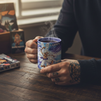 Fans Geek Store One Piece Gear 5 heat-changing ceramic mug held by a person with tattoos at a wooden desk