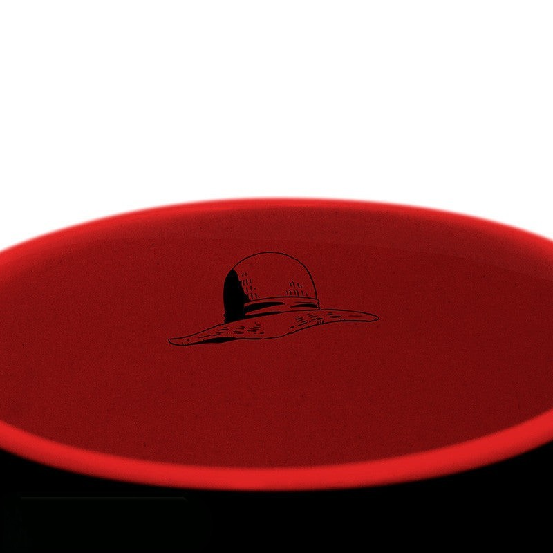 Fans Geek Store One Piece ceramic mug featuring a black exterior and a red interior with a straw hat icon