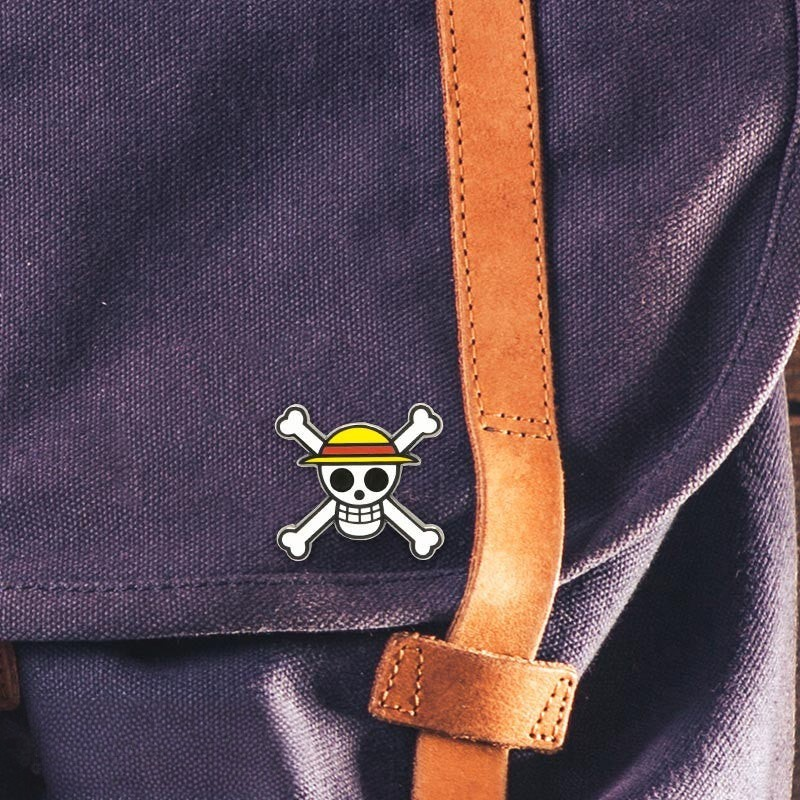 Fans Geek Store metal One Piece Straw Hat Skull pin attached to a purple fabric backpack with a brown leather strap