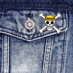 Fans Geek Store One Piece Straw Hat Skull metal pin attached to a blue denim jacket pocket