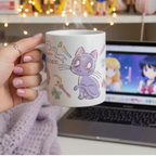 Fans Geek Store ceramic Sailor Moon mug featuring chibi Luna and Artemis, held in a hand near a laptop.