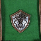Fans Geek Store The Legend of Zelda backpack featuring a detailed silver Hylian shield emblem on green fabric